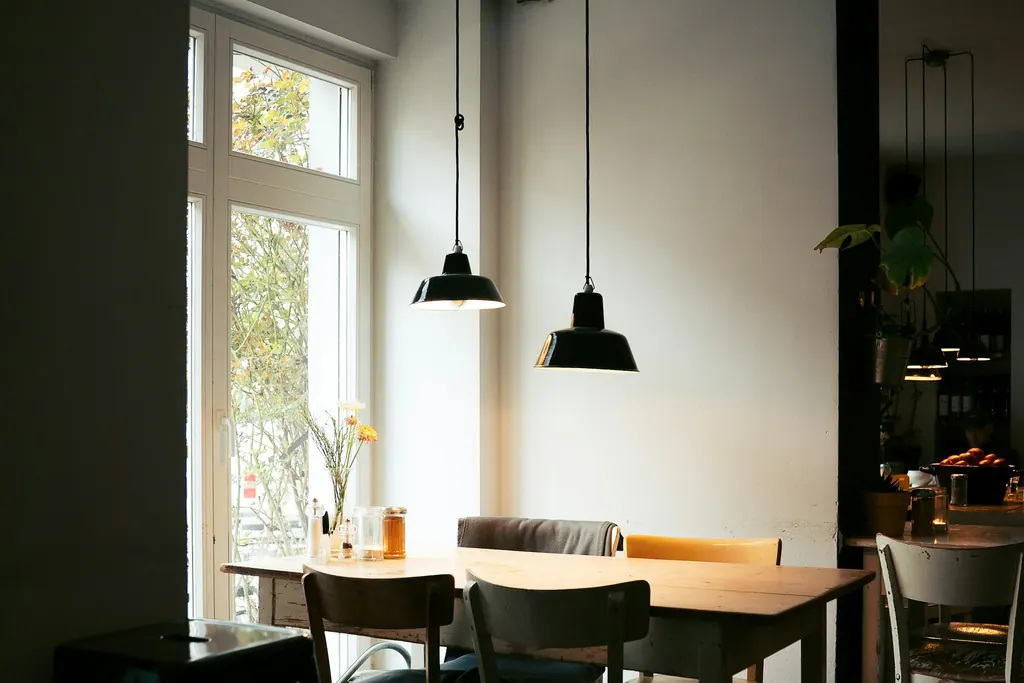A bright cafe interior with tables and chairs beside a window