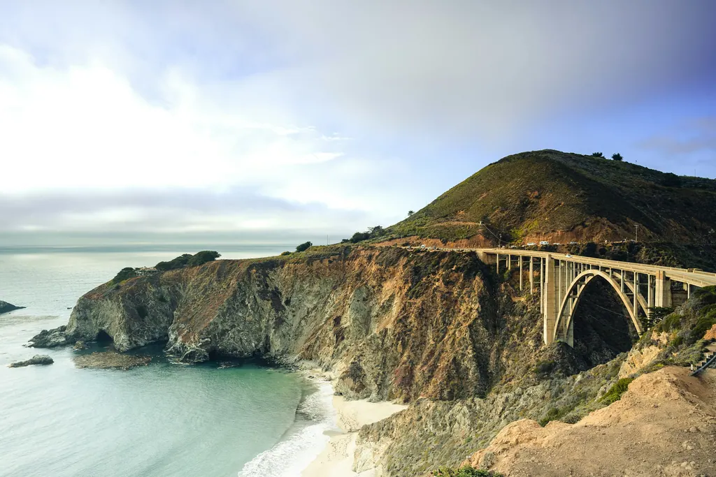 A bridge carrying a coastal highway above a turquoise cove